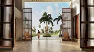 Un vestíbulo amplio con diseño moderno, que cuenta con una palmera grande y vistas al exterior.