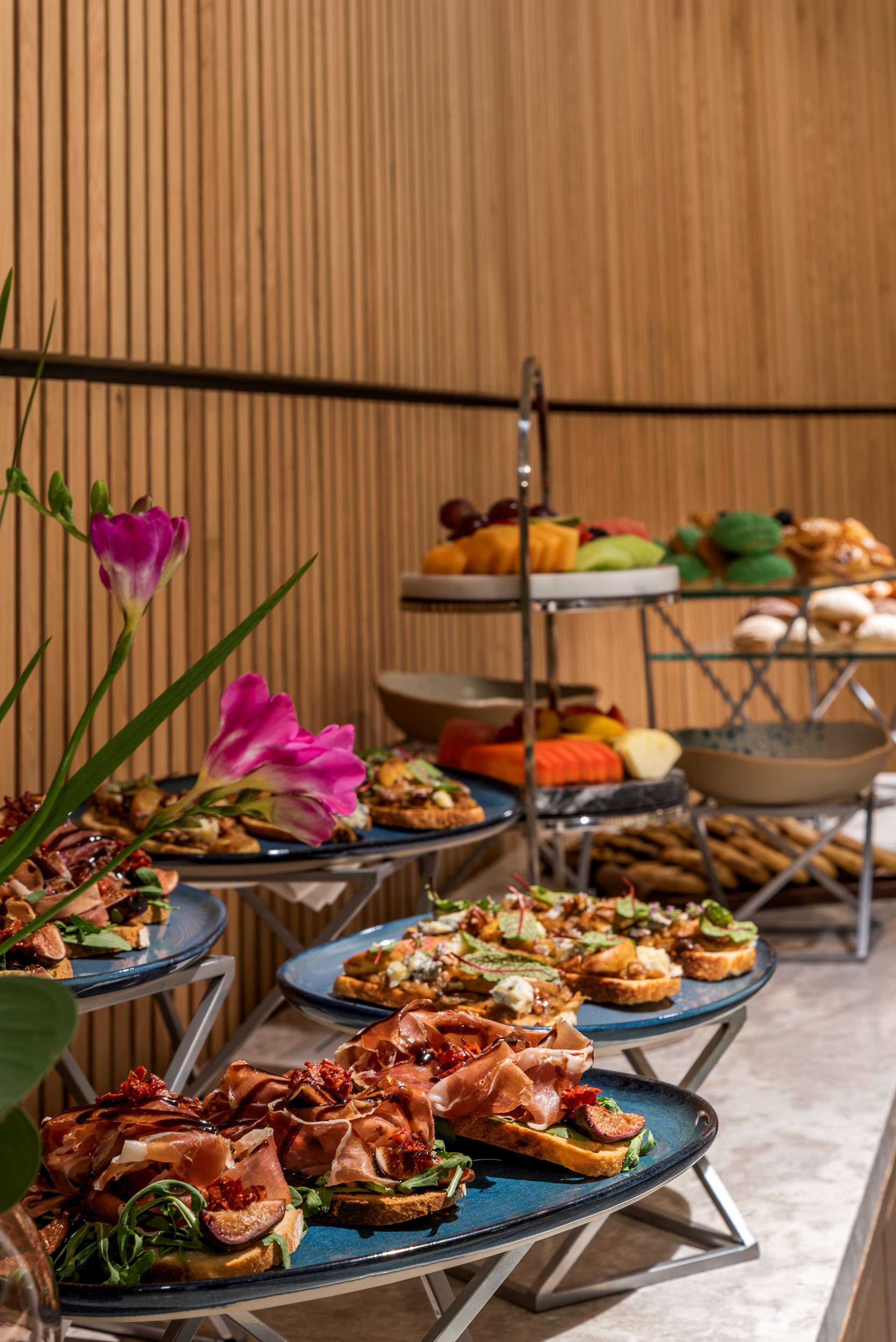 Una mesa de buffet con diferentes tipos de comida y un arreglo floral decorativo.