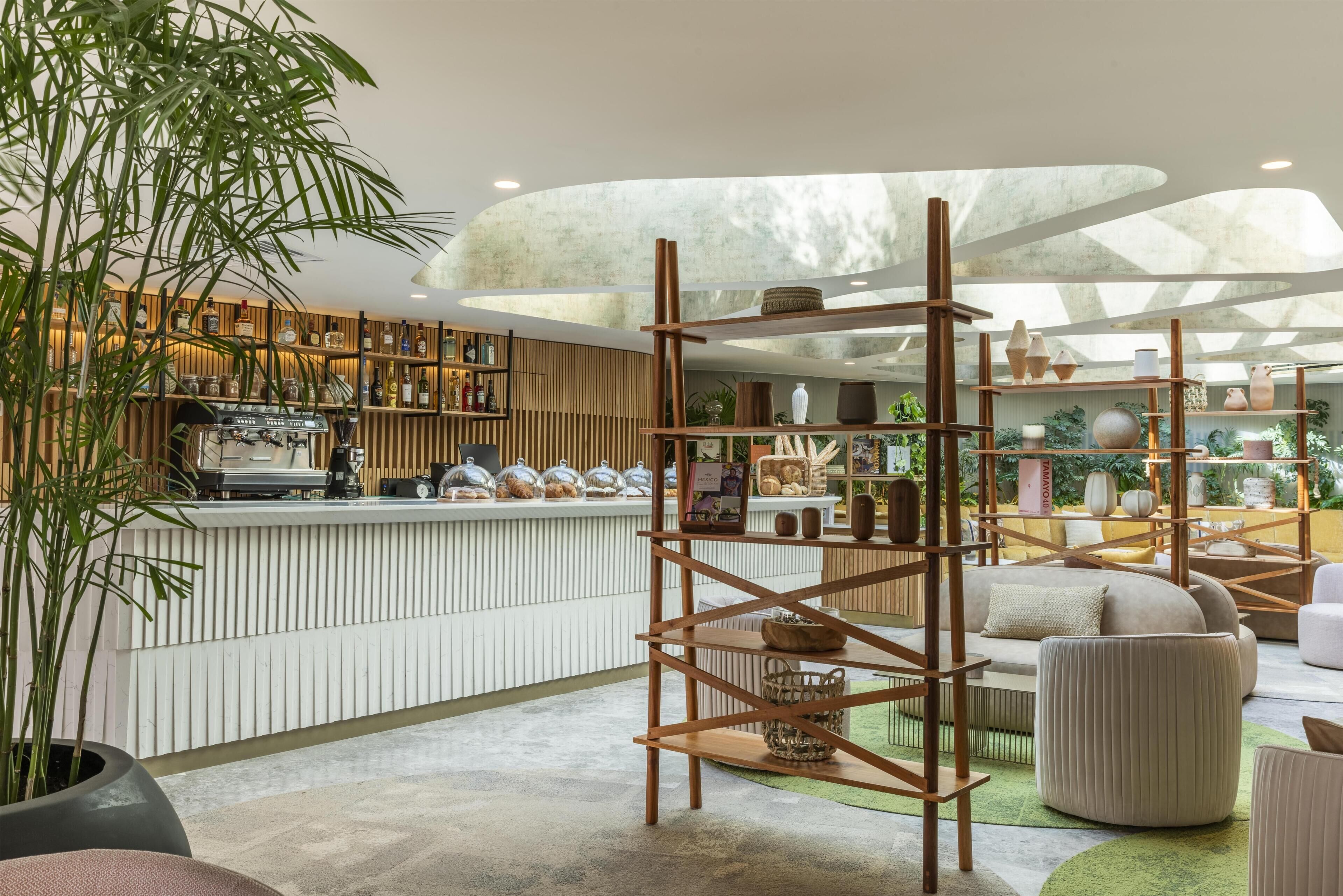 A modern interior with a wooden counter, shelves with items, and a central bamboo structure.