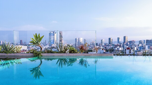 Ein klares, blaues Schwimmbecken mit einer Stadtkulisse im Hintergrund.