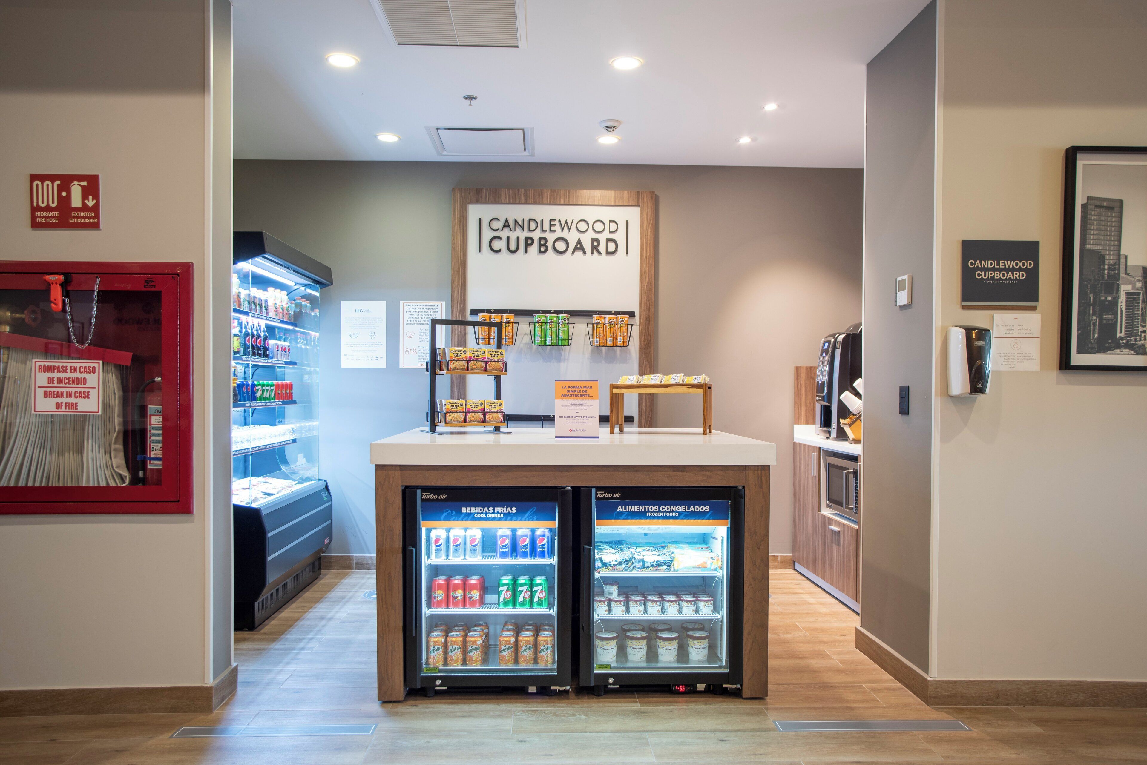 Un coin cuisine équipé d’un réfrigérateur rempli de boissons et d’un congélateur contenant des aliments surgelés.