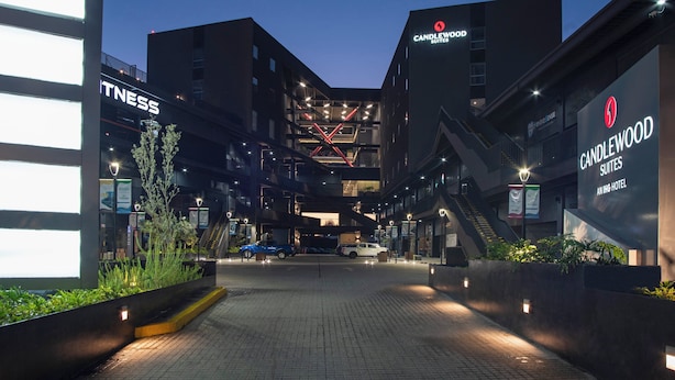 Una entrada de hotel moderna con un letrero llamativo de Candlewood Suites.
