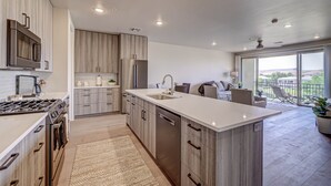 A modern kitchen with stainless steel appliances, wooden cabinetry, and a large island. - Golfers Getaway in Secluded and Quiet Setting, Golf Course and Mountain Views! (St. George)