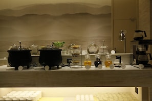 A kitchen counter with various appliances and containers, including kettles, a coffee maker, and a tea pot. - Ji Hotel (Shanghai)