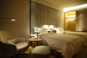 A hotel room with a bed, a chair, a bedside table, and a nightstand. - Ji Hotel (Shanghai)