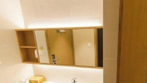 A bathroom with a mirror, a sink, and a wooden cabinet.