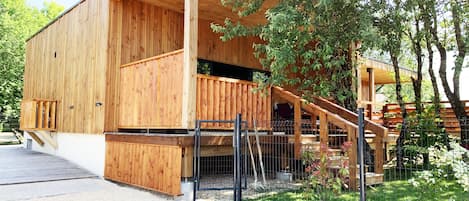 Un edificio de madera con balcón y terraza cubierta.