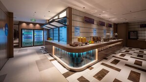 A modern hotel lobby with a curved reception desk, vending machines, and a tiled floor. - Holiday Inn Express Shanghai Pujiang Lianhang Rd M (Shanghai)