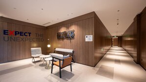 A modern lobby with a bench, chairs, and a wall with the text 'EXPECT THE UNEXPECTED.' - Holiday Inn Express Shanghai Pujiang Lianhang Rd M (Shanghai)