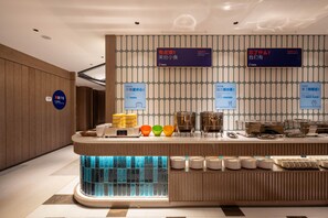 A hotel reception area with a counter, signs, and a blue-lit window.