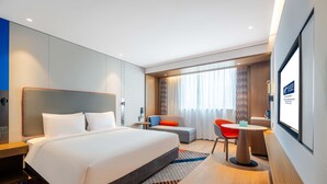 A modern hotel room with a large bed, a desk, a chair, and a TV screen. - Holiday Inn Express Shanghai Pujiang Lianhang Rd M (Shanghai)