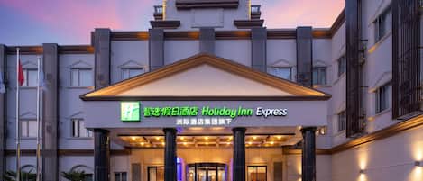 A Holiday Inn Express hotel entrance with a prominent sign, large columns, and a grand entrance.