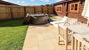 A backyard with a hot tub, a wooden deck, and a wooden cabin. - Pine Lodge (Oakham)