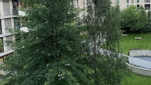 A multi-story residential building with balconies and a well-maintained lawn. - Stratford city apartment (London)