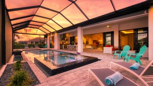 Uma área moderna de piscina externa com teto de vidro, espreguiçadeiras e um espaço para refeições.