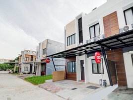 Un edificio residencial moderno con un acceso cubierto, una puerta visible y una señal que indica una zona residencial.