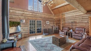 A log cabin interior with a fireplace, leather furniture, and a large window. - special offers: 20% off all winter bookings,10% discount for early reservations. (Baltimore)