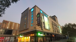 Hotellin julkisivu on moderni, siinä on kyltit, joissa lukee »dicos» ja »汉庭酒店», ja sisäänkäynti on helposti nähtävissä.