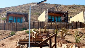 Paisaje desértico con una estructura de madera que incluye una escalera y un poste de metal.