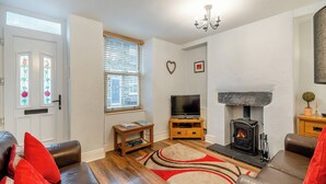 A living room with a fireplace, a television, and a sofa.