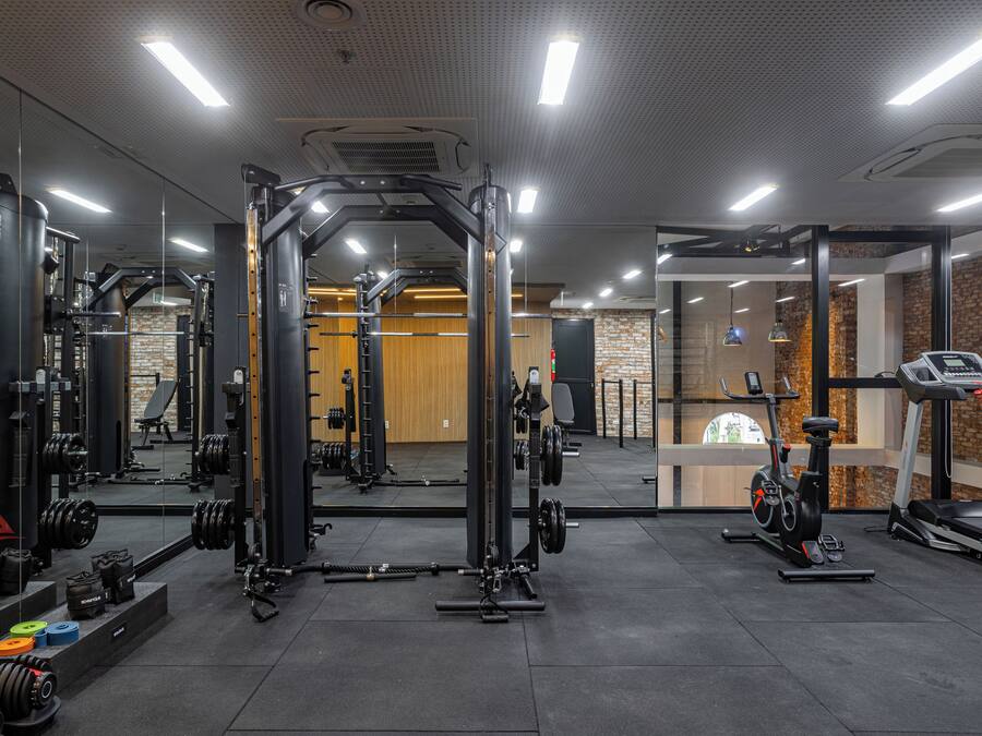 Uma academia com equipamentos de musculação, esteiras e bicicletas ergométricas.