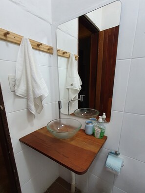 Chuveiro, secador de cabelo, toalhas de banho, papel higiênico