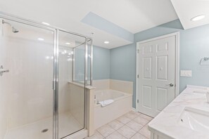 Un bagno moderno con doccia vetro, vasca freestanding e un mobile lavabo.