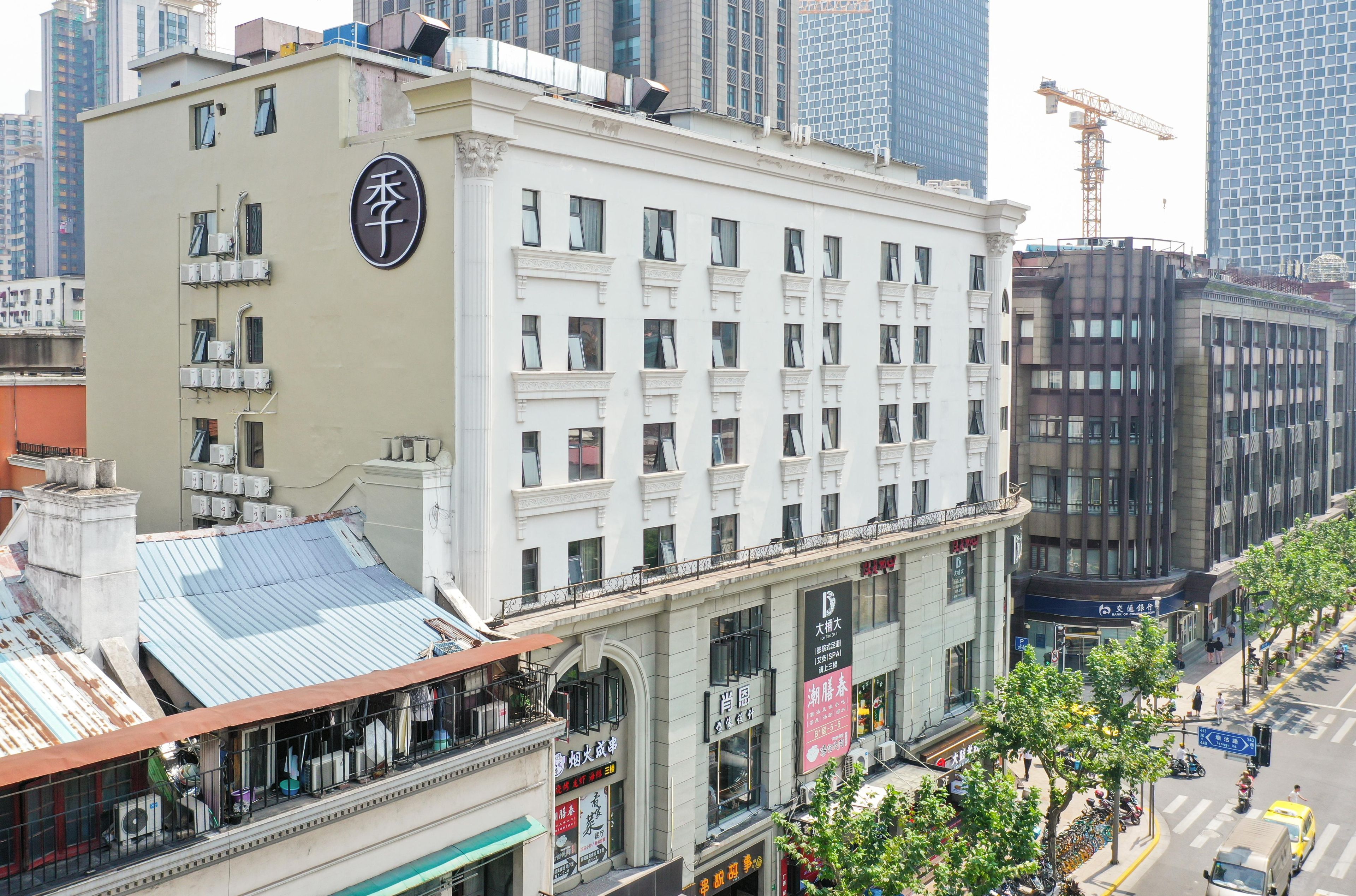 Ein mehrstöckiges Hotel mit einer auffälligen Beschilderung an der Seite, großen Fenstern und einer Dachterrasse.