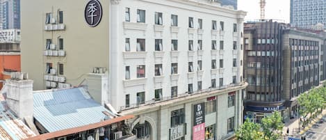 Un hôtel à plusieurs étages, doté d’une enseigne bien visible sur le côté, de grandes fenêtres et d’une terrasse sur le toit.