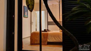 A bedroom with a bed, a nightstand, and a window. - La Villa Azur Saint-Gilles ***** - Reunion Island - Seaview, Pool, Beach & BBQ! (Saint-Gilles les Bains)
