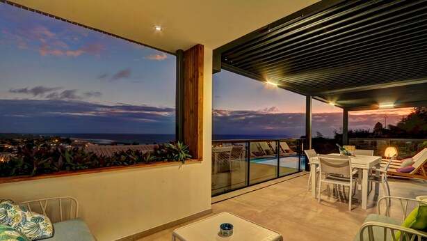 A balcony with a view of the sea, a pool, and a dining area with chairs and a table. - La Villa Azur Saint-Gilles ***** - Reunion Island - Seaview, Pool, Beach & BBQ! (Saint-Gilles les Bains)