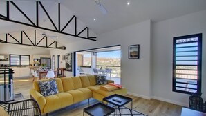 A modern living room with a yellow sofa, a dining area, and a kitchen. - La Villa Azur Saint-Gilles ***** - Reunion Island - Seaview, Pool, Beach & BBQ! (Saint-Gilles les Bains)