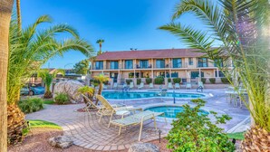 Un hôtel doté d’une piscine, de chaises longues et de palmiers.