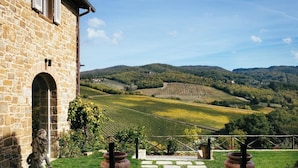 Un bâtiment en pierre offrant une vue sur les vignes et les collines.