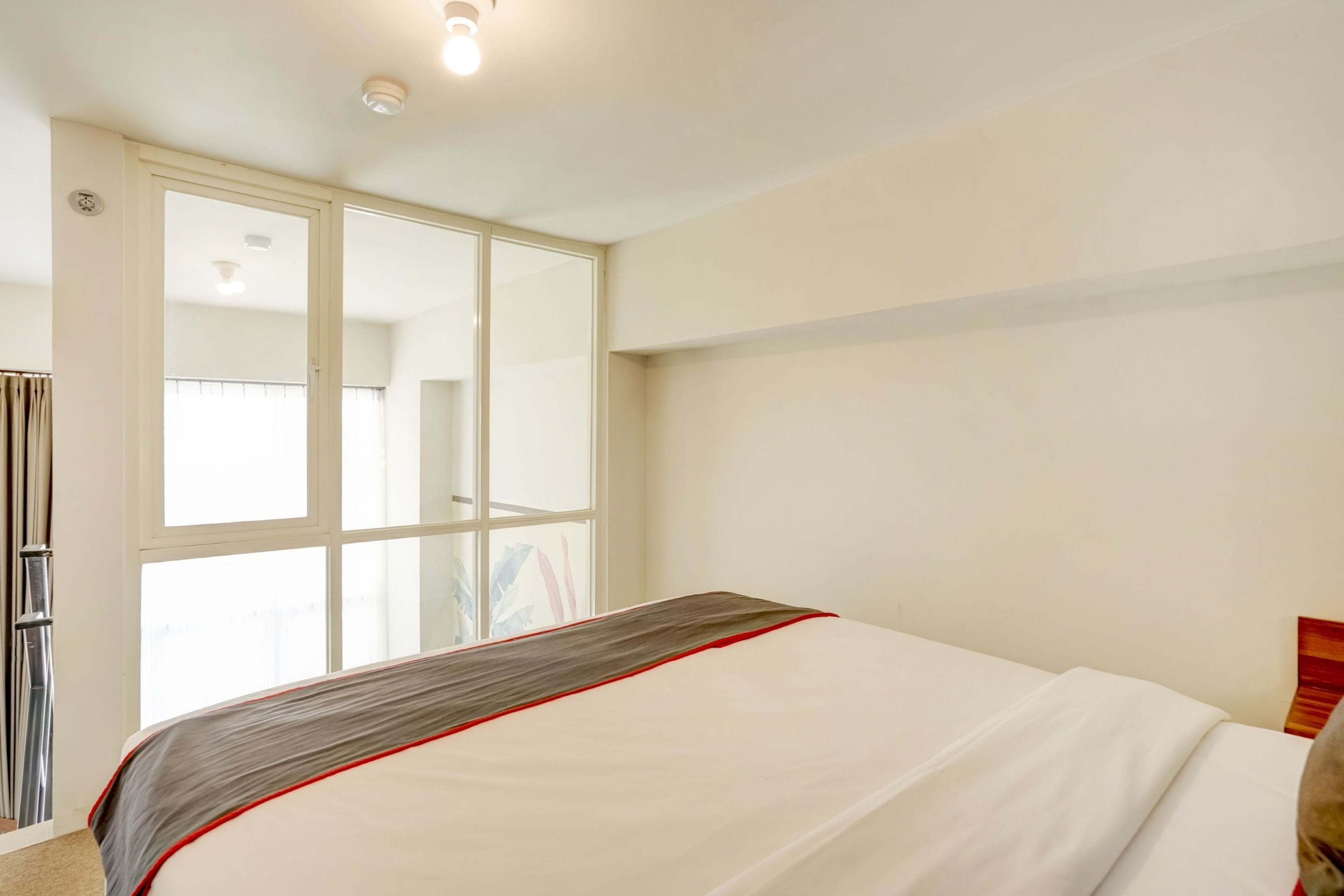 A bedroom with a bed, a wardrobe, and a window.