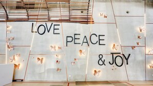 Paredes com a inscrição 'AMOR PAZ & ALEGRIA' e borboletas decorativas.