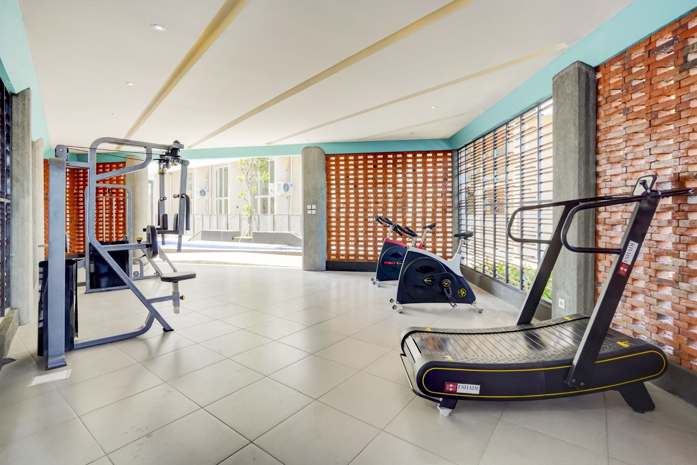 Een fitnessruimte met loopbanden, elliptische trainers en gewichten.