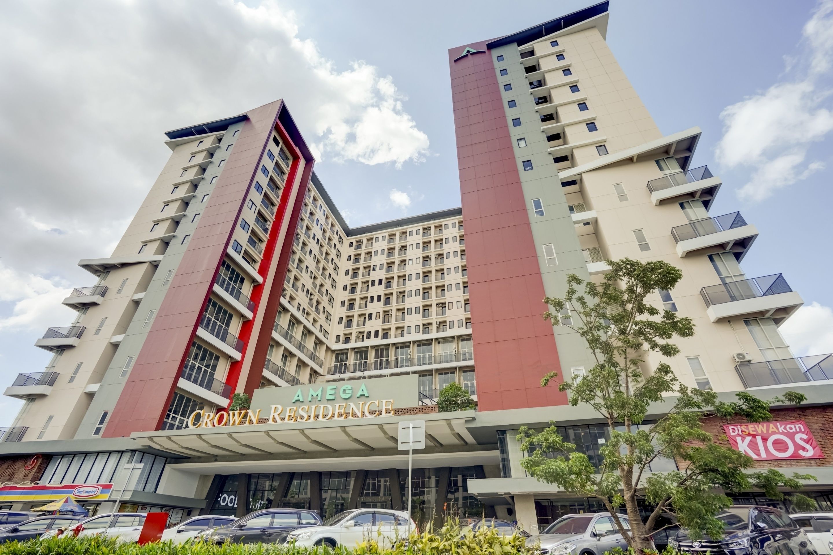 A multi-story building with a prominent sign for 'AMEGA Crown Residence.'