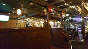 A restaurant interior with brick walls, hanging lights, and festive decorations. - Big Family House 5 Minutes from Lake Michigan/Blue Chip Casino/Brewery/Wineries! (Michigan City)