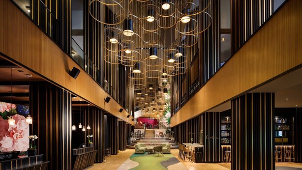 A hotel lobby with a central staircase, a reception desk, and a bar area. - The Starling Atlanta Midtown, Curio Collection by Hilton (Atlanta)