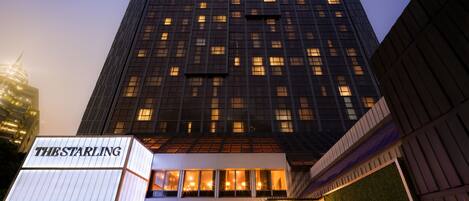 Un edificio de hotel moderno con un letrero llamativo que dice "THE STARLING" en la entrada.