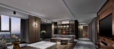 A modern living room with a large TV, comfortable seating, and a view of the city.