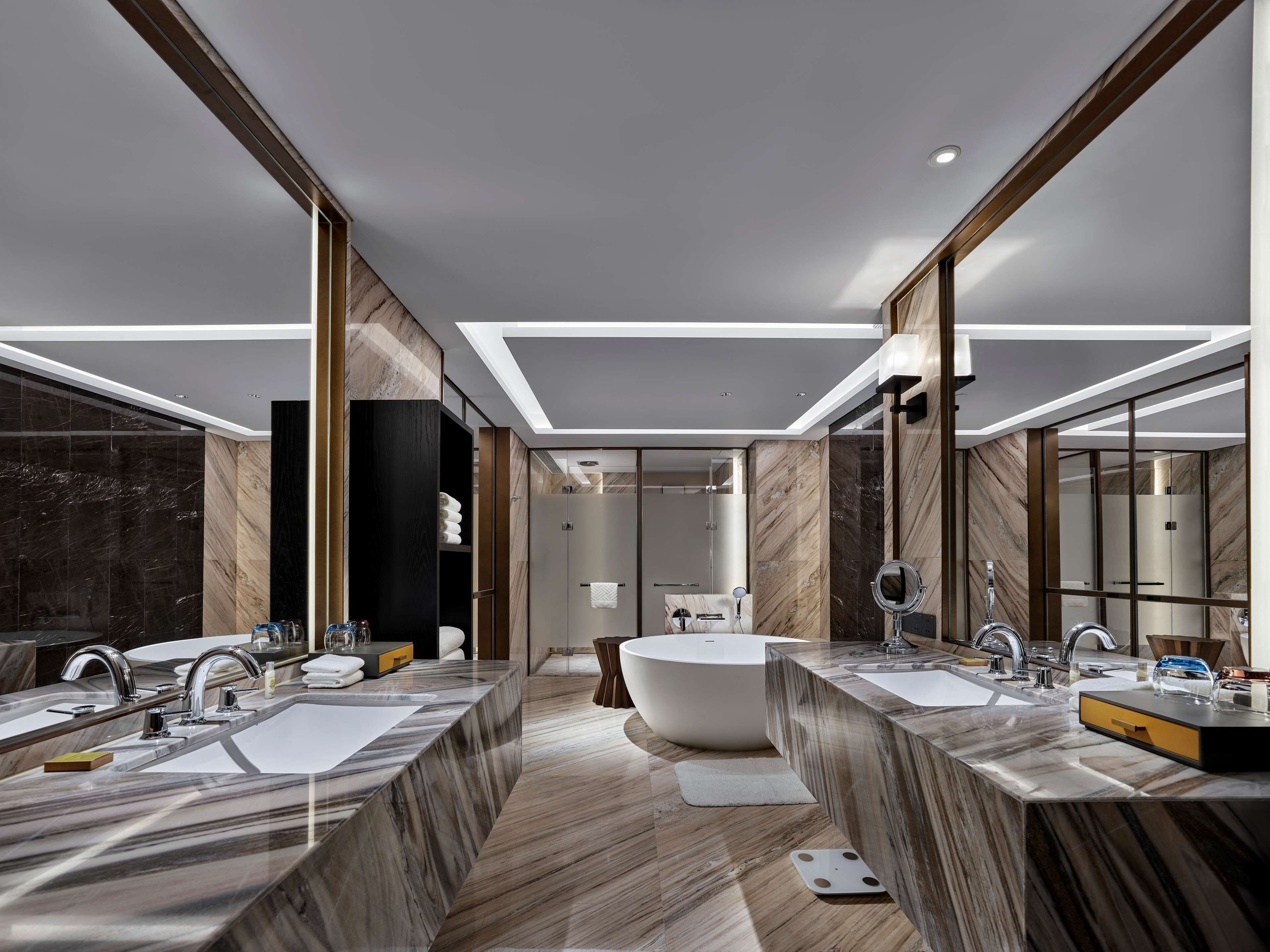 A modern bathroom with two sinks, a bathtub, and a walk-in shower.