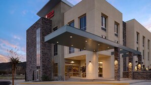 A modern hotel with a stone facade, large windows, and a covered entrance. - Hilton Garden Inn Temecula, CA (Temecula)