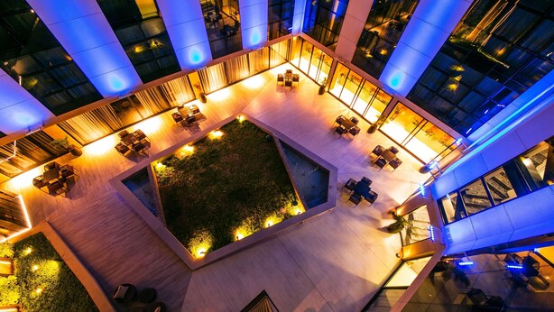 A spacious atrium with multiple seating areas and a central garden.
