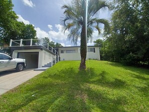 A modern house with a garage, a white exterior, and a well-maintained lawn. - Cozy and Beautiful 4/2 Florida Home __ Promo $135 nightly. BOOK NOW (Beverly Hills)