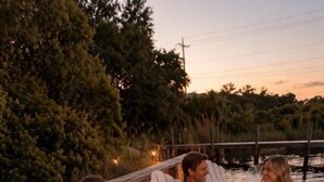 A group of people seated on white chairs on a wooden deck with a view of a body of water and trees. - Lakefront Home Close to the Beach! Sleeps 16 (Santa Rosa Beach)