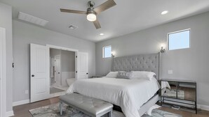 A bedroom with a large bed, a bench, a ceiling fan, and a nightstand. - “WATERS-EDGE” A WATERFRONT home! Hot Tub!! VIEWS!!! (Canyon Lake)