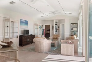 Relax in this open-plan living area with a sofa, armchairs, and a flat-screen TV.