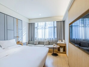 A hotel room with a large bed, a sofa, a TV, and a window with curtains. - JI Hotel (Hangzhou West Lake Hubin Jiefang Road) (Hangzhou)